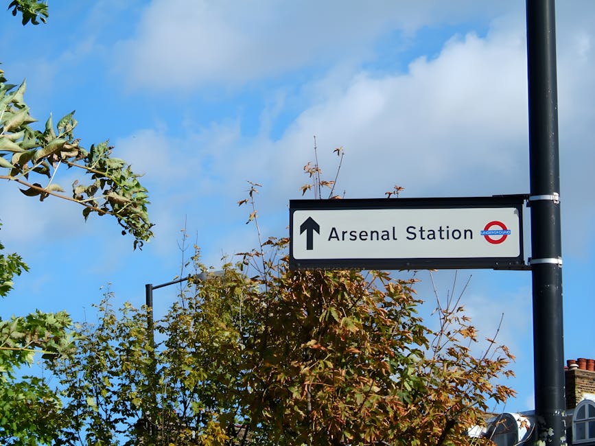 The image depicts an underground train station platform with multiple railway tracks running parallel, constructed with dark grey paving and bordered by yellow tactile paving along the edge for safety